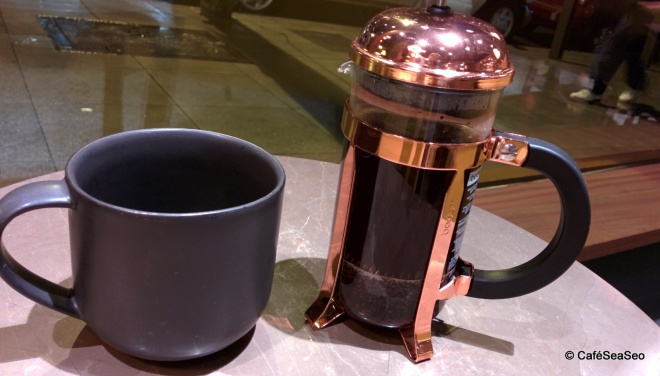 Starbucks Reserve Roastery & Tasting Room - My mug of Pantheon blend coffee next to the coffee press (French press) that brewed it